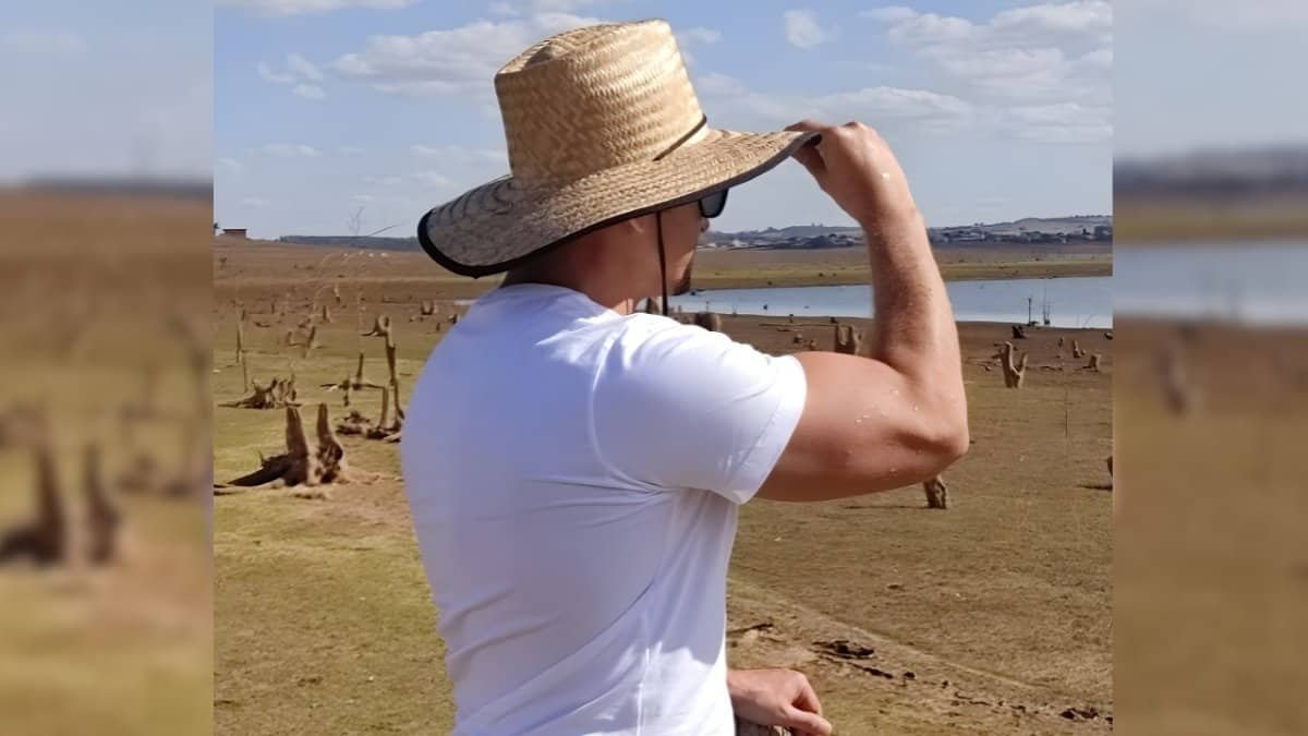 Homem treinando ao ar livre com chapéu de palha, focado na rotina de musculação e desenvolvimento fí.